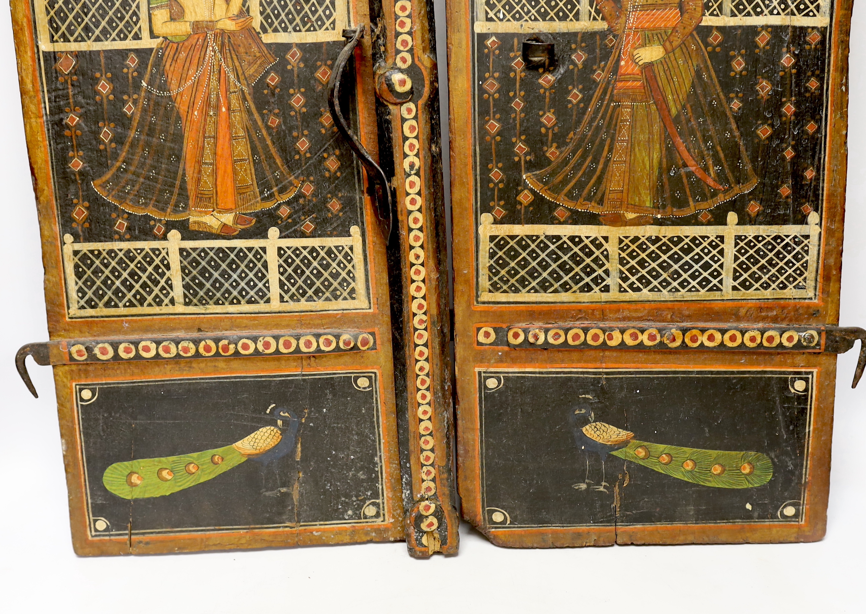 A pair of painted Indian shutters hand painted with figures and birds, 67cm high